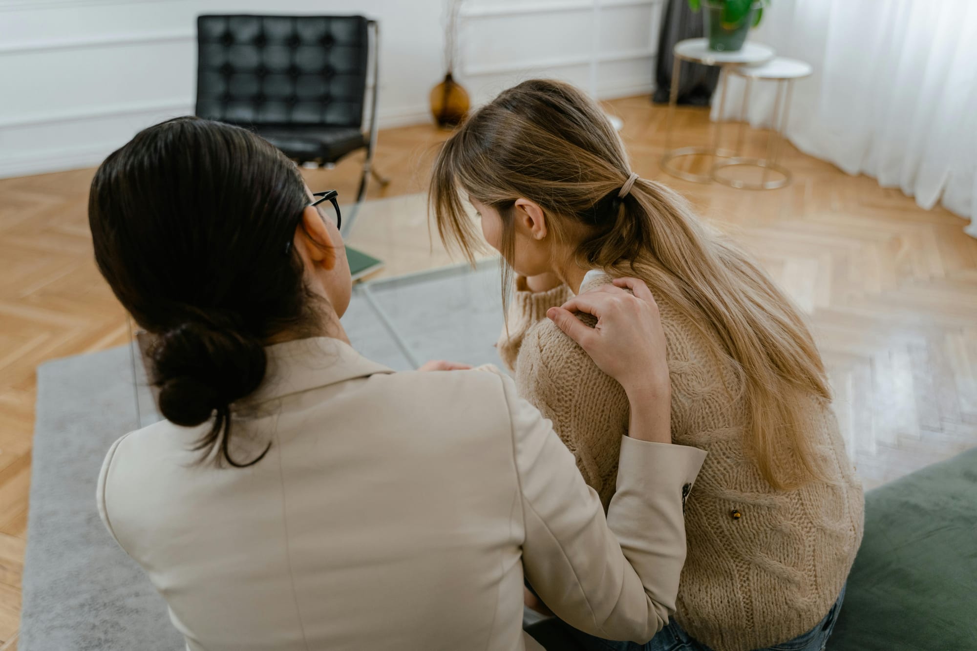 Therapist with a patient putting her hand on her shoulder