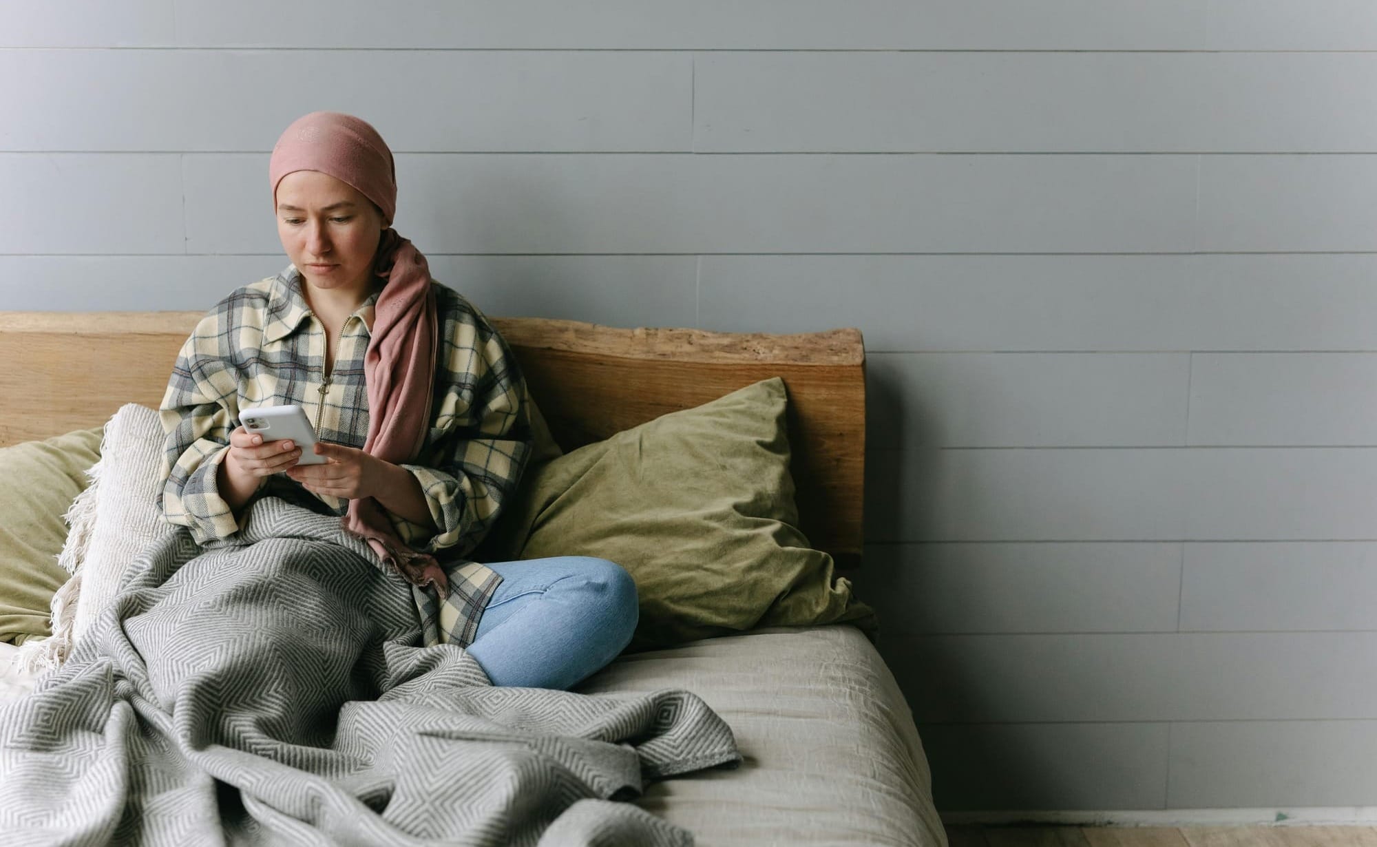 Woman sitting in bed and looking at her phone