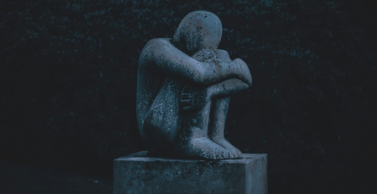 A statue of a depressed man