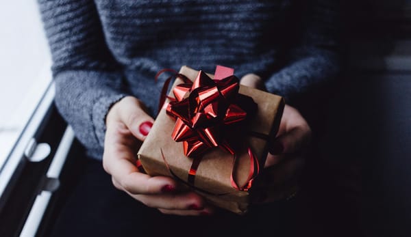 a woman holding a small gift